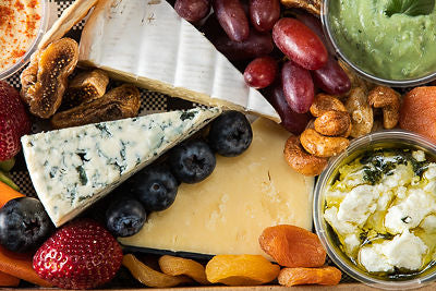 Close up of a cheese and antipasto box with fresh fruit