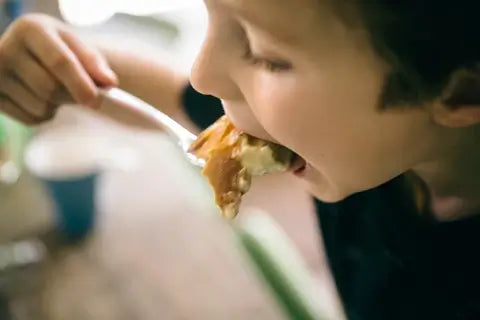 Child eating a spoonful of food